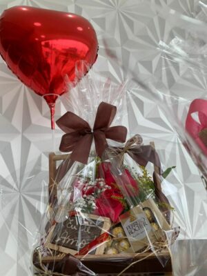 Cesta de aniversário com arranjo de rosas, chocolates e balão